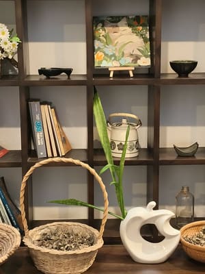 Kệ gỗ với sách, giỏ mây và đồ gốm